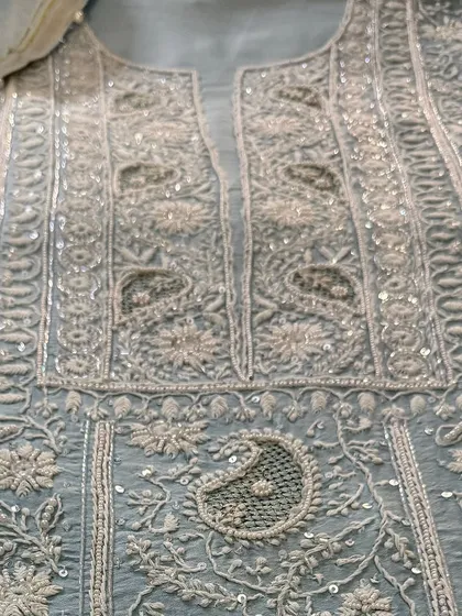 A close-up of the yoke, where the intricate paisley motifs and Kutdana embellishments are clearly visible.