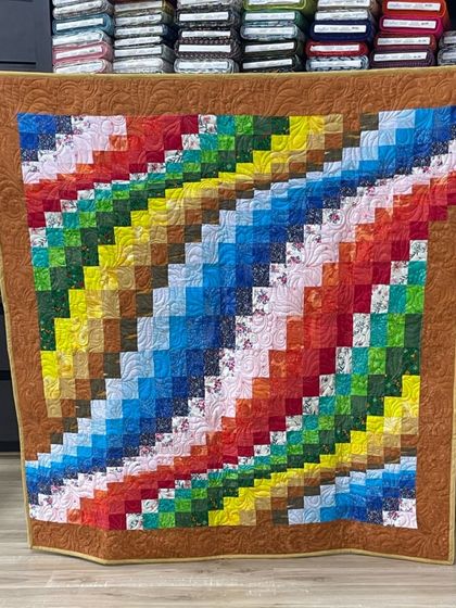 A "color wash" or bargello-style quilt with a rainbow of colors flowing diagonally across the piece.