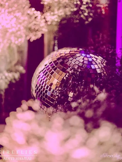 A detail shot of a disco ball amidst baby's breath, reflecting the purple light and adding to the glitz and glam of the Sangeet night.