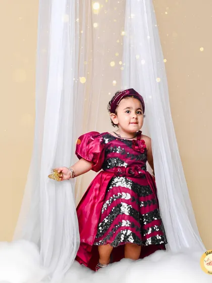 Every girl can be a princess. This elegant portrait with a sequined dress and dreamy white curtains creates a fairytale moment for your little one.