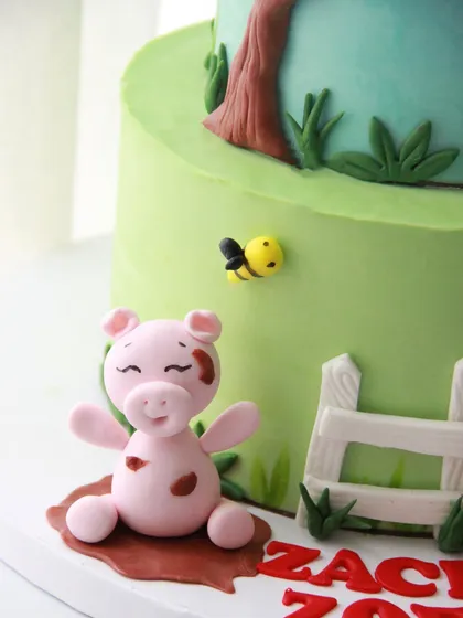This happy little pig playing in the "mud" adds a touch of fun to the farm-themed cake.