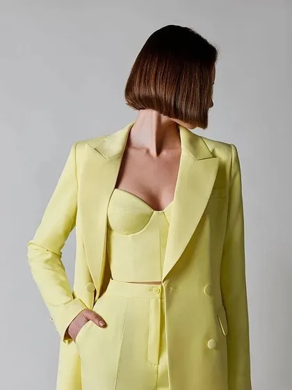 A bright and cheerful take on the power suit, this lemon-yellow set includes a double-breasted blazer and a matching bustier top, perfect for making a statement.