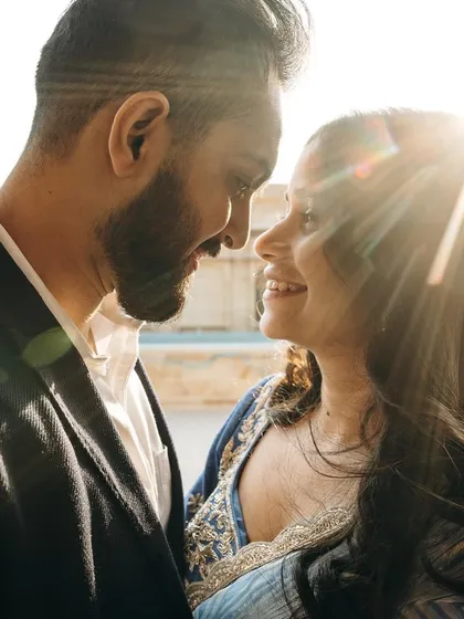 A close up shot capturing the beautiful backlighting. The makeup is designed to look flawless even in bright, direct sunlight, with a focus on smooth skin and defined features.