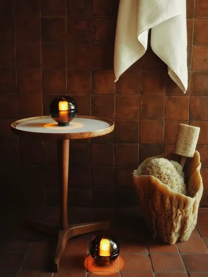 The Bocci 14p portable lamps in a bathroom setting. Their warm, rippling glow creates a serene, spa-like atmosphere. They are available in Clear, Grey, and Sepia glass.
