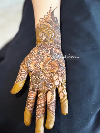 This design features a beautiful cuff at the wrist, transitioning into a detailed pattern on the hand. The finger designs are intricate and unique.