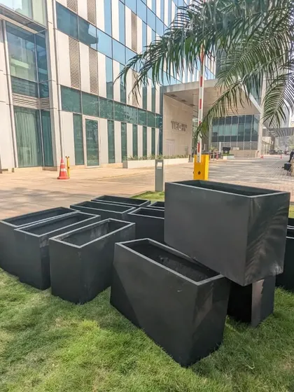 A collection of the unboxed black FRP planters ready for the next phase. Their matte finish provides a sophisticated and modern look that complements the building's architecture.