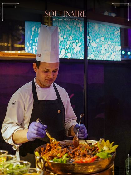 A chef at a live station preparing a traditional Indian curry, showcasing our expertise in a wide range of culinary styles.