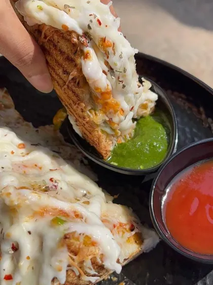 Dipping a slice of my cheesy open toast into our signature green chutney. The combination of flavours is simply irresistible.