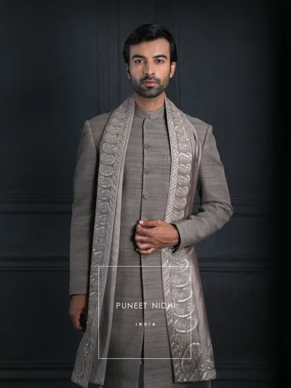 A closer look at the brown matka silk achkan with its richly embroidered paisley stole. The combination of earthy tones and metallic threads creates a look of understated luxury.