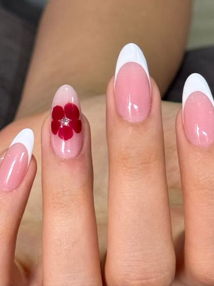 A closer look at the elegant white French manicure with a single, detailed 3D red flower accent nail.