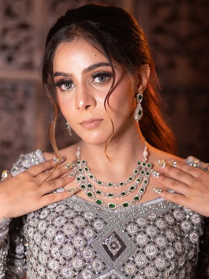 The full jewellery set, including the necklace and earrings, is perfectly matched to enhance the beauty of this silver-grey outfit.