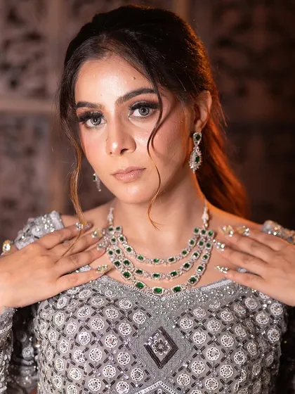 The full jewellery set, including the necklace and earrings, is perfectly matched to enhance the beauty of this silver-grey outfit.