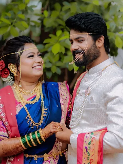 A joyful, candid close-up of the bride and groom sharing a laugh, showcasing the beautiful details of their Maharashtrian wedding look.