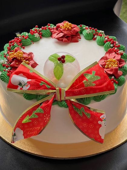 A simple and beautiful Christmas cake with a festive bow and poinsettia decorations. Merry Christmas to all!
