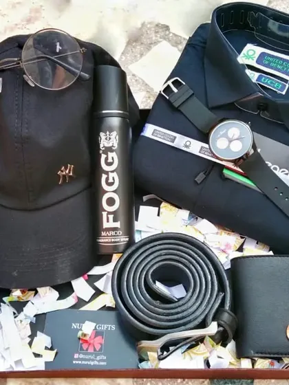 A stylish black-themed hamper with a UCB shirt, a personalized wallet, a watch, a cap, sunglasses, a belt, and Fogg perfume.