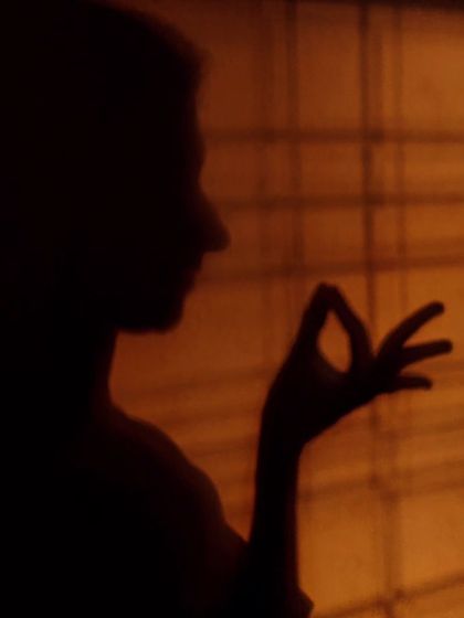 A simple play of light and shadow, creating a silhouette of the 'Hamsasya' hasta. This hand gesture is used to denote many things, including a pearl, a drop of water, or the act of drawing.