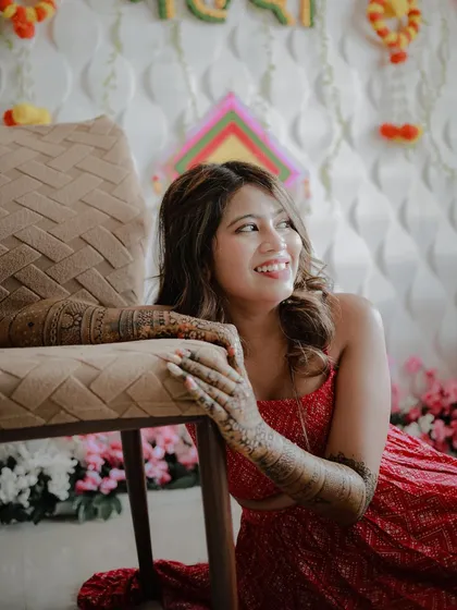 A lovely candid portrait of the bride looking away with a happy smile. This shot captures her natural joy and the beautiful details of her mehndi.