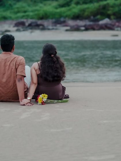 The couple sits on the sand, looking out at the water together. This quiet, serene photo from their Kokan pre-wedding shoot is a beautiful depiction of shared peace.
