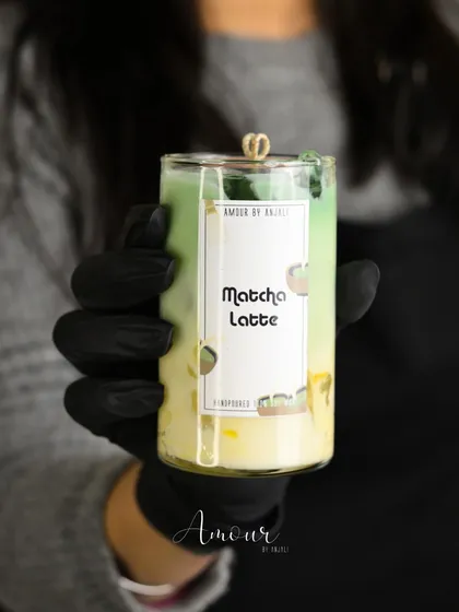 A handheld view of the Iced Matcha Latte candle. The layers of green and white wax create a realistic and beautiful effect.