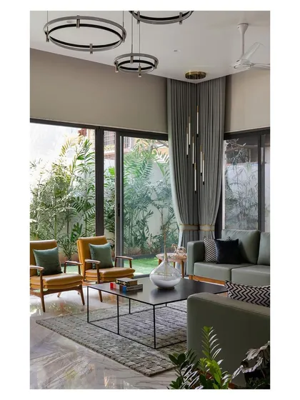 The living room of the "Solid | Void | Solid House" opens completely to a lush garden. The use of a neutral color palette with green accents blurs the line between inside and out.