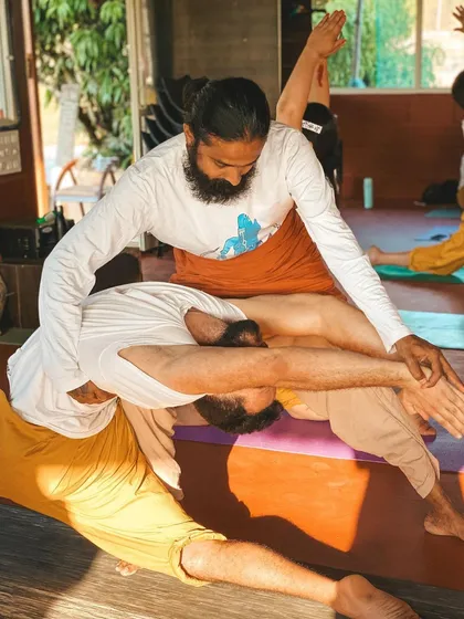 A student receives an assist in a challenging balancing pose. My role is to provide the stability they need to explore the posture without fear of falling.