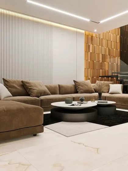 In this living room, we focused on creating a warm and inviting atmosphere with a rich, earthy color palette. The space features a comfortable sectional sofa, elegant marble flooring, and a modern floating staircase with a glass balustrade that maintains an open feel.