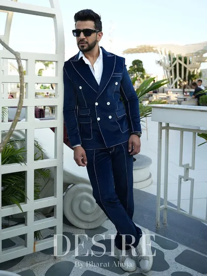 Leaning with effortless cool, this shot showcases the rich color and sharp lines of the blue velvet suit.