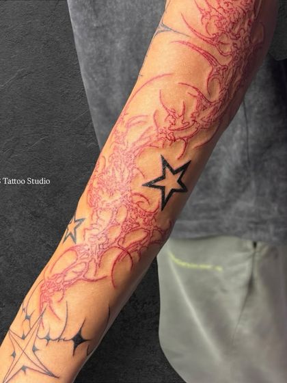 A close-up look at the intricate red linework in the neo-tribal sleeve.