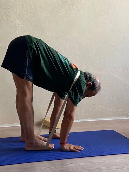 A standing forward bend with a strap.