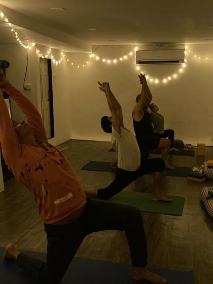 Our evening yoga class, holding a low lunge variation to open the hips and stretch the spine. The soft lighting helps create a calm and focused environment.