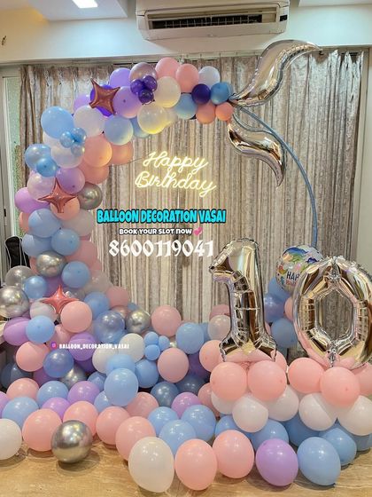 A pastel mermaid theme for a 10th birthday. This setup features a half-arch of balloons on a frame, with silver foil number balloons.