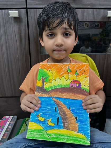 A first-grade student displays his imaginative landscape drawing. My classes are designed to spark creativity, offering a world of vivid colours and limitless possibilities for young artists.