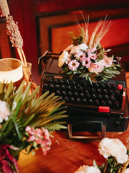 An antique typewriter adorned with fresh flowers, adding to the nostalgic theme.