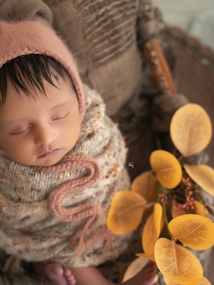 A beautiful portrait angle, focusing on the baby's face while still showing the lovely textures and colours of the rustic setup.