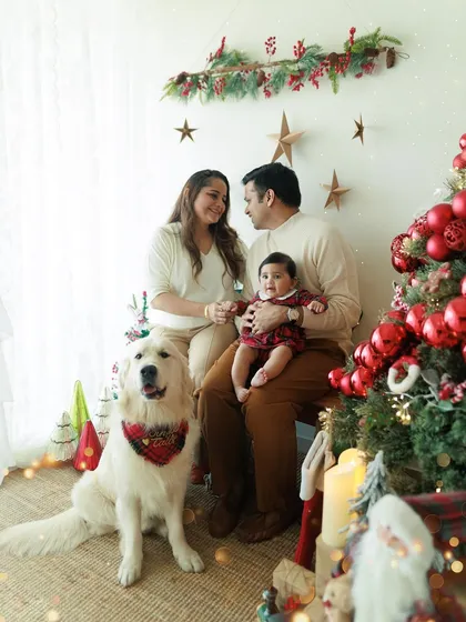 Cherished moments with the whole family, including the four-legged members. This Christmas portrait captures the holiday joy with parents, their baby, and their beautiful dog.