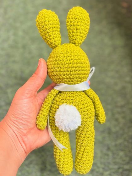 A back view of the lime green bunny, showing off its cute and fluffy tail.