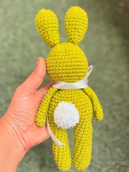 A back view of the lime green bunny, showing off its cute and fluffy tail.
