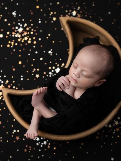 Another perspective of the starry night theme, this image captures the baby's peaceful slumber as he floats in a galaxy of golden stars.