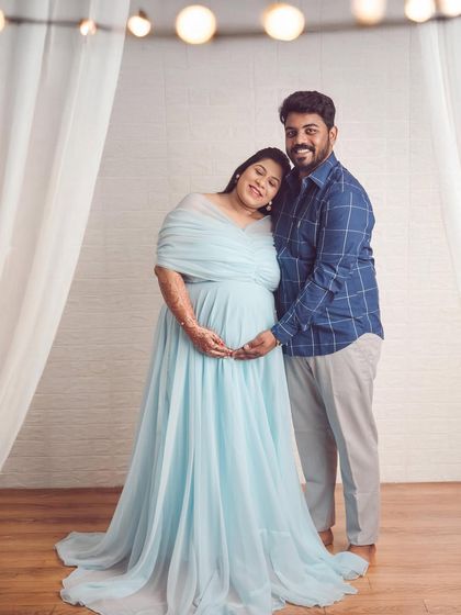 A simple and elegant couple's portrait. The soft blue gown and the warm lighting from the cafe bulbs create a cozy and intimate atmosphere.