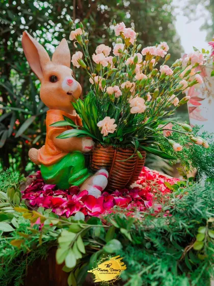 A charming detail featuring a rabbit figurine holding a basket of flowers, nestled on a bed of petals. It’s these sweet, whimsical touches that bring a fairy-tale quality to the decor.