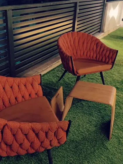 Stylish and comfortable outdoor chairs with intricate woven backs, perfect for a modern terrace lounge.