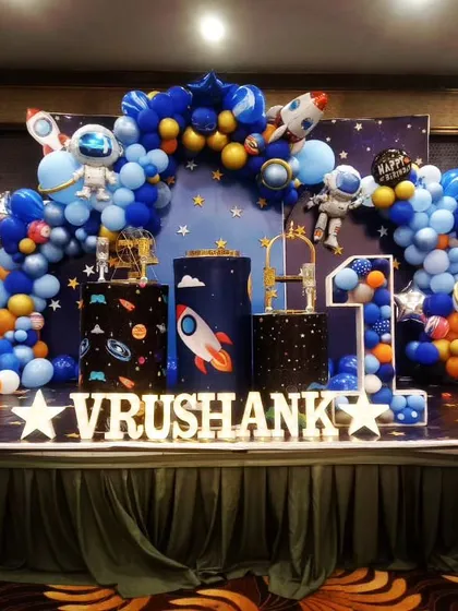 Three, two, one, blast off! We designed this out-of-this-world space theme for Vrushank's first birthday. The setup features a galaxy-themed backdrop, planet and astronaut props, and a stunning balloon arch in shades of blue and orange to create a cosmic adventure.