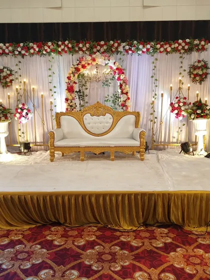 A duplicate image of a classic and elegant stage setup for a wedding reception or engagement, showcasing the floral arch and chandelier.