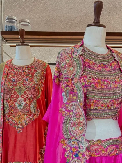 A display of heavily embroidered festive wear from Petticoat Lane, featuring a stunning pink lehenga with a multi-colored jacket.