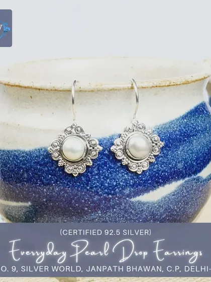 Another variation of our everyday pearl drop earrings, this pair features a pearl set within a scalloped, floral-inspired silver frame.