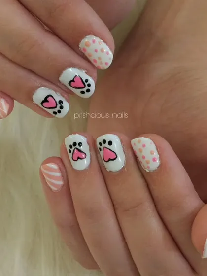 How cute are these cat paw nails? This adorable hand-painted design features little pink and black paw prints on a white base.