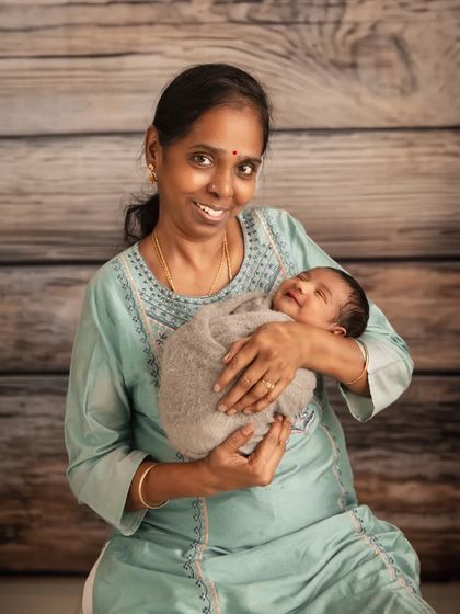 The joy of a grandmother holding her new grandchild. The baby's sweet smile makes this a truly precious moment, showing how we can include the entire family in newborn sessions.