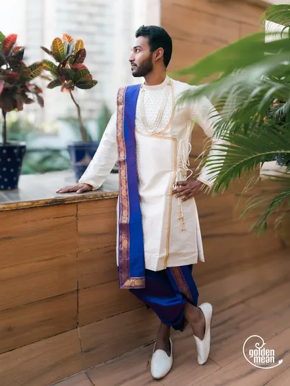 A handsome groom in a traditional dhoti and kurta, looking sharp and ready for his wedding ceremony.