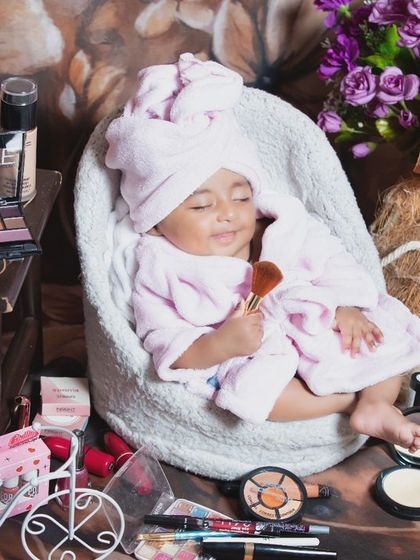 Our little spa-goer is enjoying her beauty treatment, surrounded by makeup and flowers.