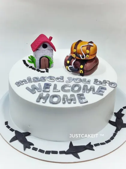 A simple and sweet "Welcome Home" cake for a brother returning from his travels. The edible luggage and house toppers tell a lovely story.